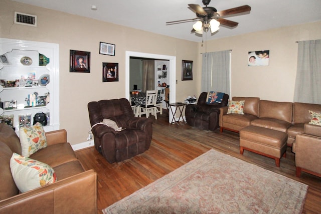 living room with dark hardwood / wood-style flooring and ceiling fan