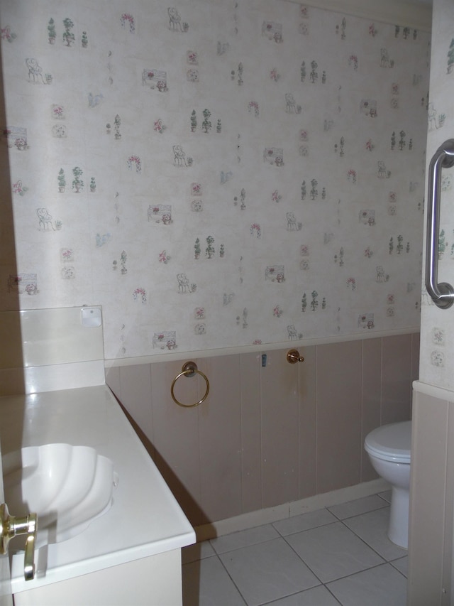 175 Isom St, Lumberton, TX 77657 - bathroom featuring wallpapered walls, vanity, tile patterned flooring, and a wainscoted wall