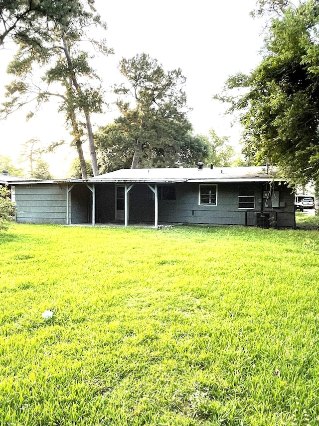 5335 Landry Ln, Beaumont, TX 77708 - rear view of property featuring a yard and central AC