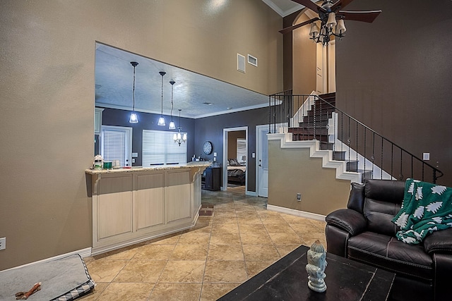 living room with ceiling fan, crown molding, and a high ceiling