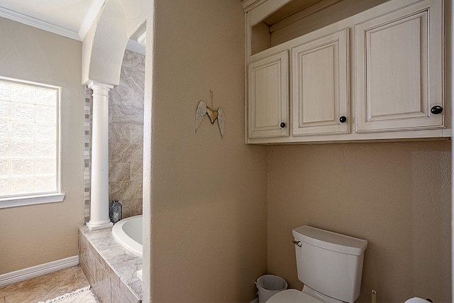 bathroom featuring tiled tub, toilet, crown molding, and tile patterned flooring