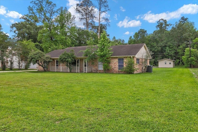 ranch-style home featuring central AC unit, a front lawn, covered porch, and a shed