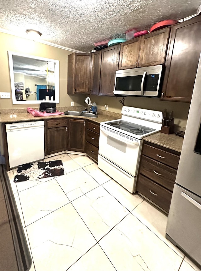 kitchen with sink, a textured ceiling, dark brown cabinets, light tile patterned floors, and appliances with stainless steel finishes