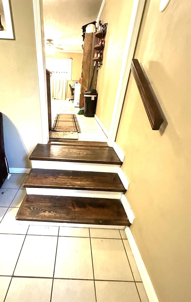 stairway featuring tile patterned floors and ornamental molding