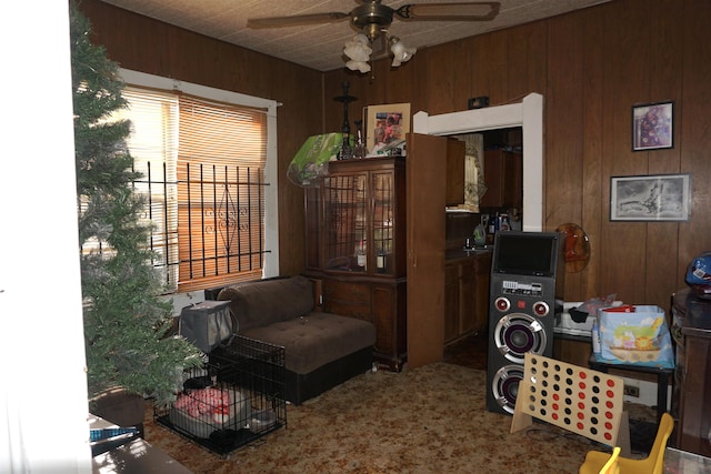 1720 Elgie St, Beaumont, TX 77705 - living area featuring wood walls, a ceiling fan, and carpet flooring