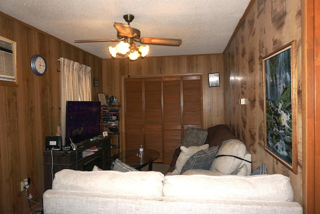 1720 Elgie St, Beaumont, TX 77705 - living area featuring wooden walls, a ceiling fan, and a textured ceiling