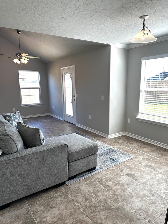 living room with ceiling fan, a healthy amount of sunlight, lofted ceiling, and a textured ceiling