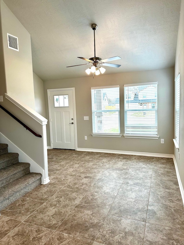 foyer featuring a textured ceiling, ceiling fan, and lofted ceiling