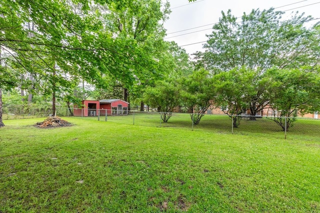 view of yard featuring fence and an outbuilding