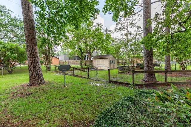 view of yard featuring an outdoor structure, a shed, and a fenced backyard