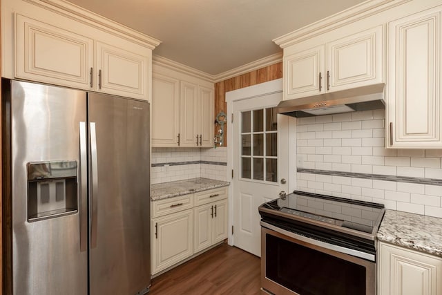 kitchen featuring tasteful backsplash, stainless steel appliances, cream cabinets, and under cabinet range hood