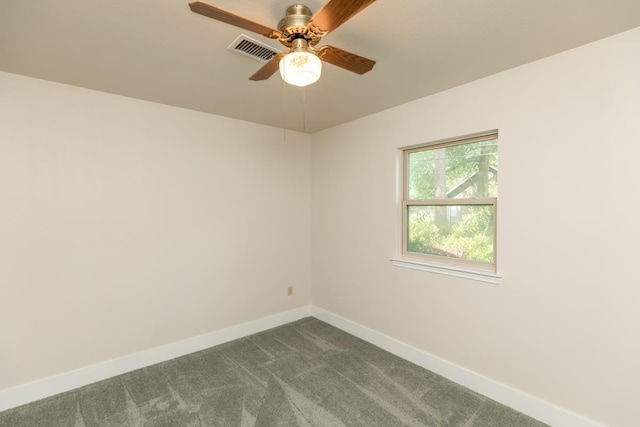 spare room with baseboards, dark colored carpet, visible vents, and ceiling fan