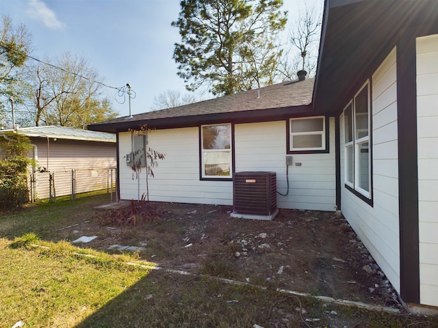 rear view of property featuring a yard and central AC