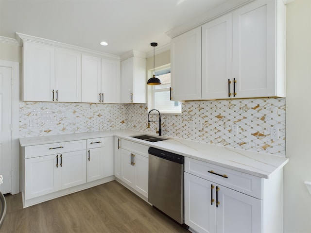 kitchen with sink, white cabinetry, light stone counters, stainless steel dishwasher, and pendant lighting