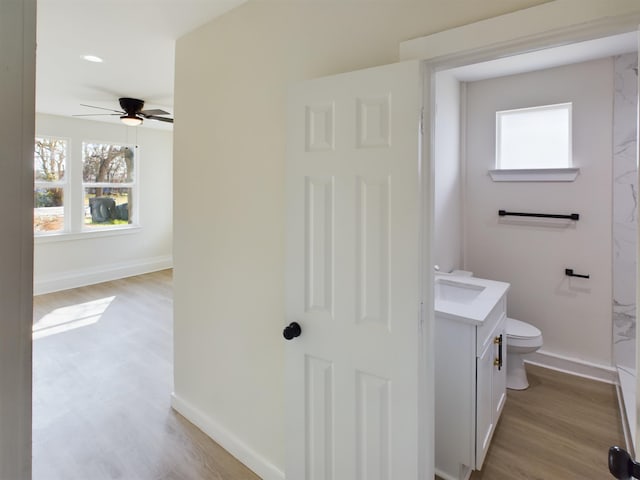 bathroom featuring vanity, hardwood / wood-style flooring, plenty of natural light, and toilet