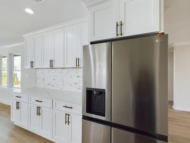 kitchen with white cabinetry, light stone counters, crown molding, and stainless steel refrigerator with ice dispenser