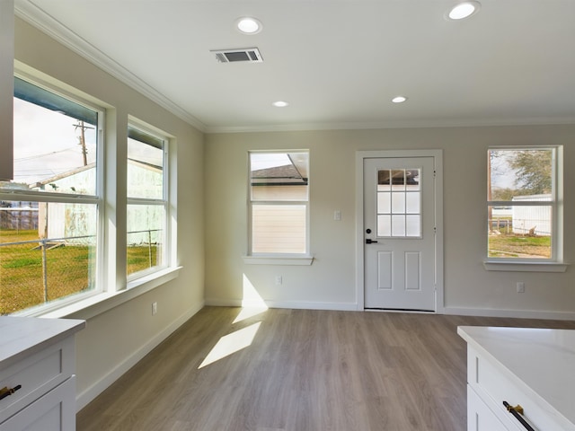 entryway with crown molding and light hardwood / wood-style floors