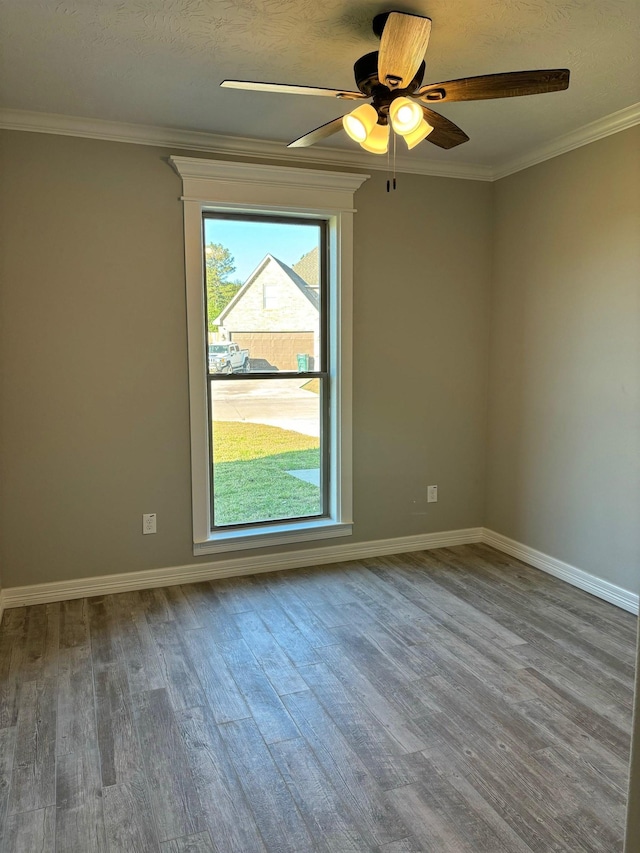 unfurnished room with ceiling fan, hardwood / wood-style floors, a textured ceiling, and ornamental molding