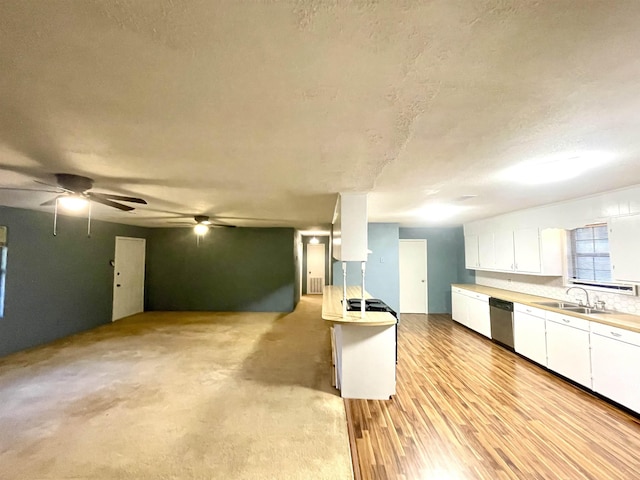 kitchen featuring white cabinetry, sink, stainless steel dishwasher, a textured ceiling, and light wood-type flooring