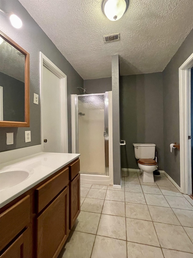 bathroom with tile patterned floors, vanity, walk in shower, and a textured ceiling