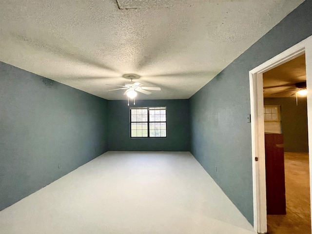 empty room with a textured ceiling and ceiling fan