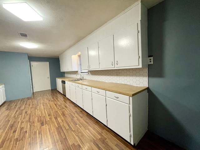 kitchen with tasteful backsplash, a textured ceiling, sink, dishwasher, and white cabinets