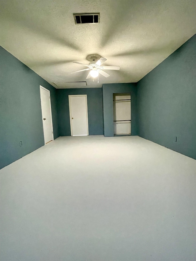 unfurnished room featuring ceiling fan and a textured ceiling