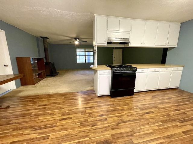 kitchen featuring ceiling fan, black stove, light hardwood / wood-style flooring, a textured ceiling, and white cabinets