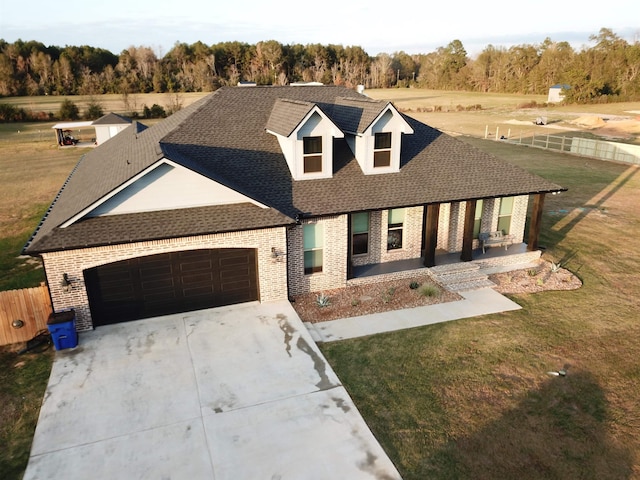 view of front of property with covered porch, a garage, and a front lawn