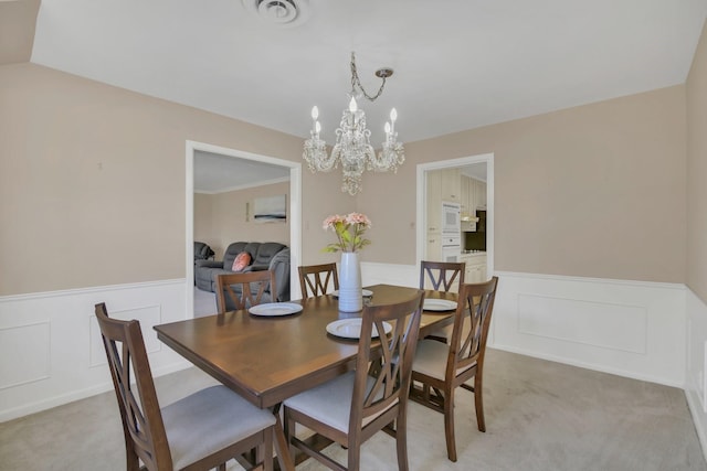 carpeted dining space featuring an inviting chandelier