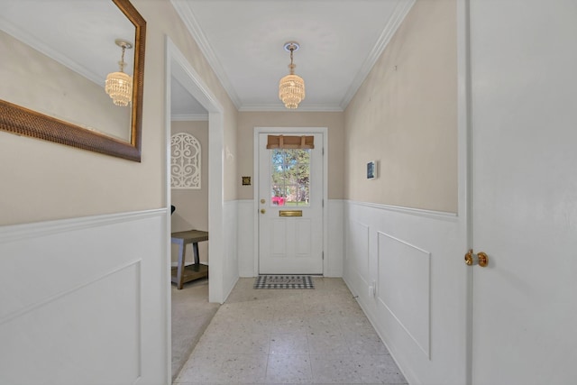 doorway to outside featuring ornamental molding and an inviting chandelier