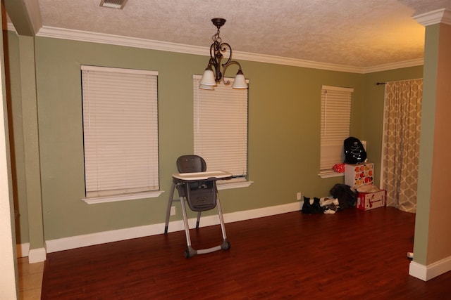 misc room with ornamental molding, a textured ceiling, and a notable chandelier