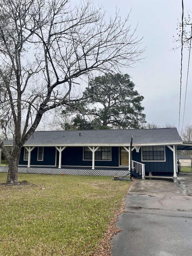 view of front of property with a carport and a front lawn