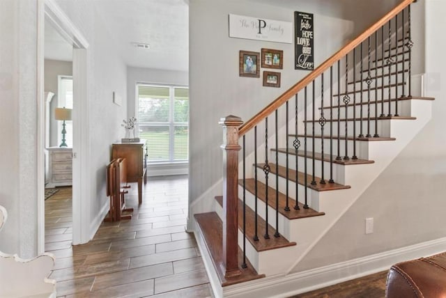 stairway with wood tiled floor and baseboards