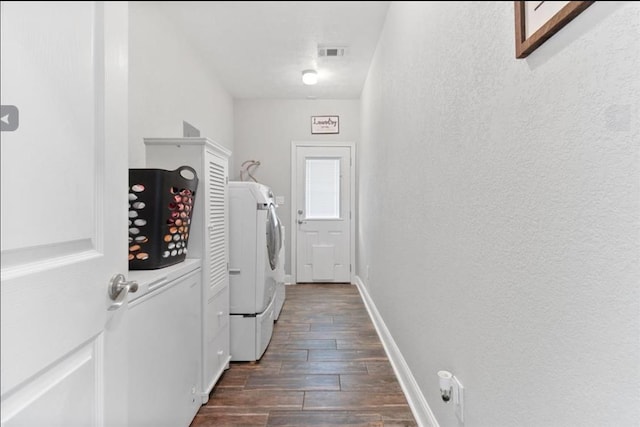 laundry area with laundry area, baseboards, visible vents, washer and clothes dryer, and wood finish floors