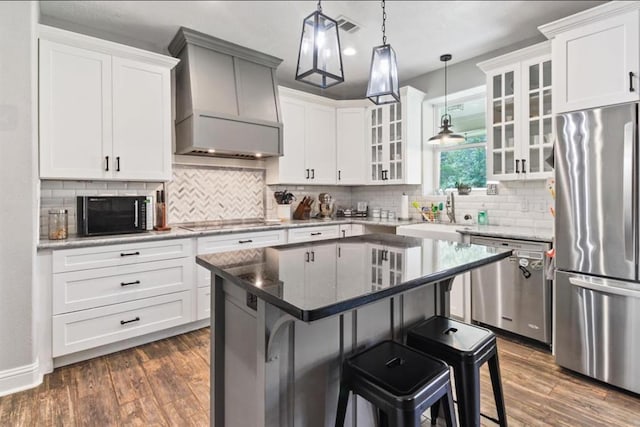 kitchen featuring stainless steel appliances, a kitchen breakfast bar, dark wood-type flooring, and custom exhaust hood