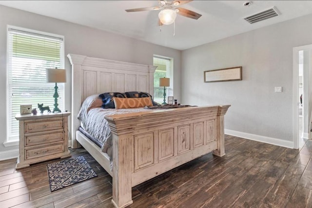 bedroom featuring baseboards, visible vents, dark wood finished floors, and a ceiling fan