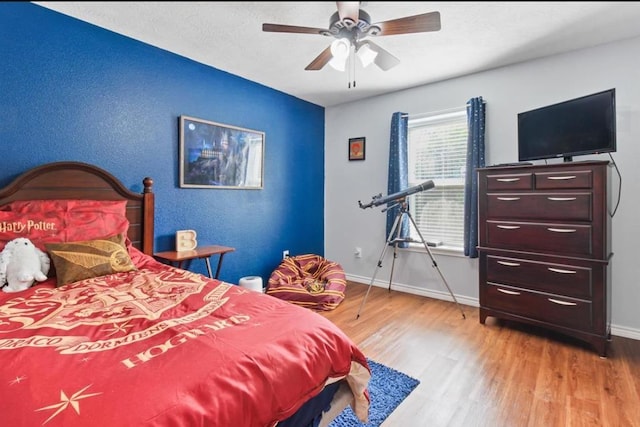 bedroom featuring light wood-style flooring, baseboards, and ceiling fan