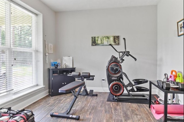 workout area with baseboards and wood finished floors