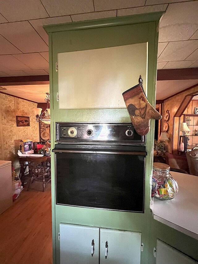 details with wood finished floors, oven, and a paneled ceiling