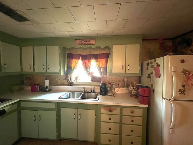 kitchen featuring a sink, light countertops, and freestanding refrigerator