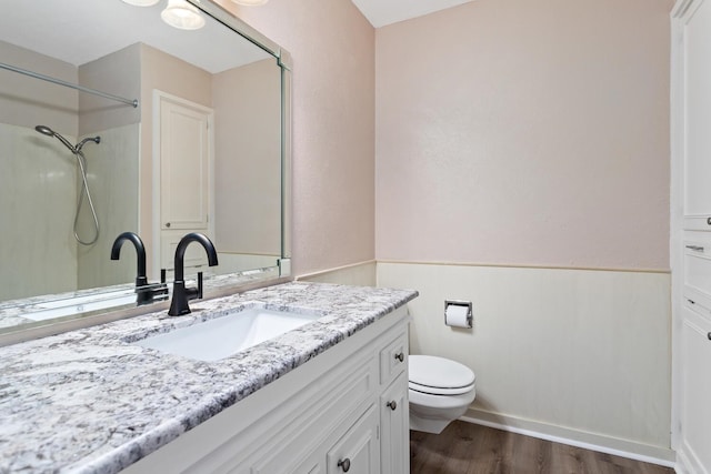 bathroom featuring wood-type flooring, vanity, toilet, and walk in shower