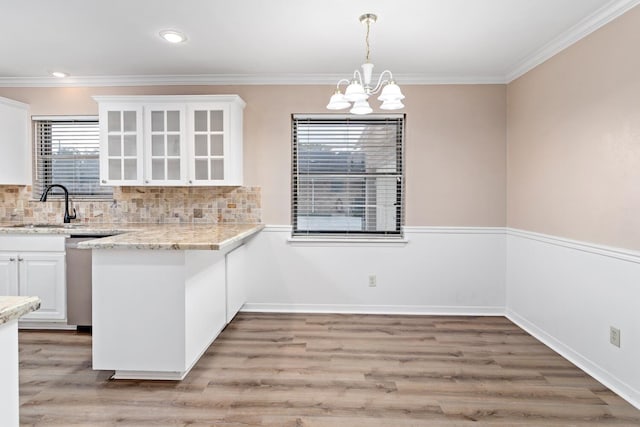 kitchen with white cabinets, crown molding, and sink