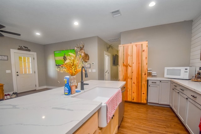 2000 Aggie Dr, Beaumont, TX 77713 - kitchen featuring white microwave, light wood-style floors, light stone countertops, a ceiling fan, and recessed lighting