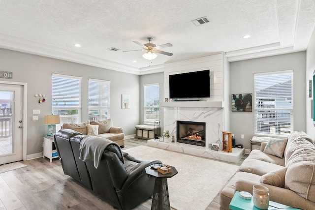 living room featuring a healthy amount of sunlight, a textured ceiling, and light wood-type flooring