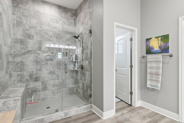 bathroom with hardwood / wood-style flooring and a shower with door