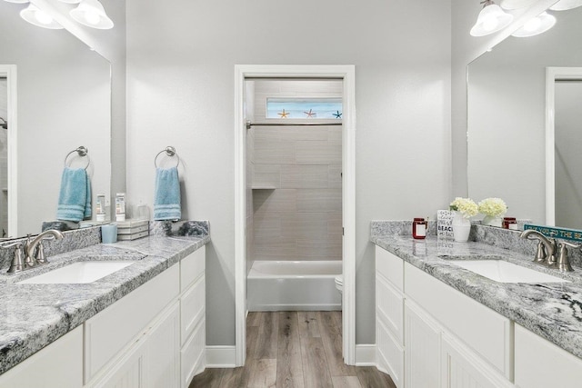 bathroom featuring vanity, wood-type flooring, and washtub / shower combination