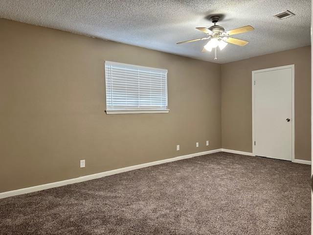 carpeted empty room featuring ceiling fan and a textured ceiling