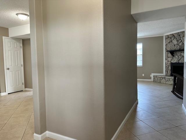 hall with light tile patterned floors and a textured ceiling