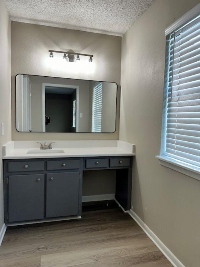 bathroom featuring vanity, wood-type flooring, and a textured ceiling